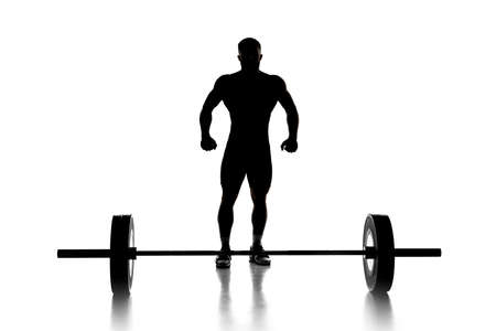 Full length portrait of a man in sportswear exercising with a weight isolated on white backgroundの写真素材