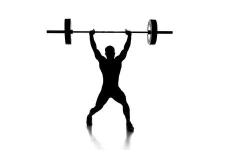 Full length portrait of a man in sportswear exercising with a weight isolated on white backgroundの写真素材