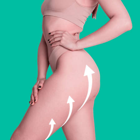 Beautiful female body in beige underwear over green background. Beauty, fitness conceptの写真素材