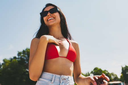 Young smiling woman, girl in sunglasses having rest, sunbathing outdoors in bright summer day.