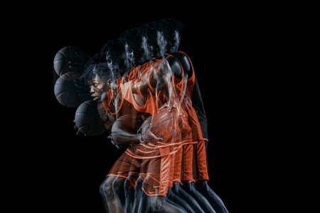 Young african man, basketball player in motion with ball isolated over black background. Stroboscopic effectの写真素材