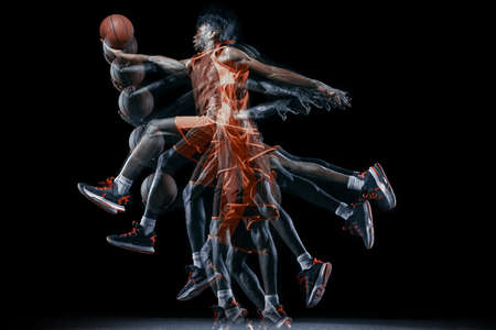 One young african man, basketball player in motion with ball isolated over black background....