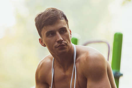 One young handsome caucasian man resting after training at crossfit ground on bright summer day.の写真素材