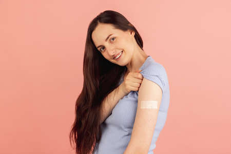 Vaccination. Portrait of young Caucasian woman posing isolated on pink pastel background.
