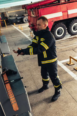 One male firefighter dressed in uniform with protective helmet at fire stationの写真素材