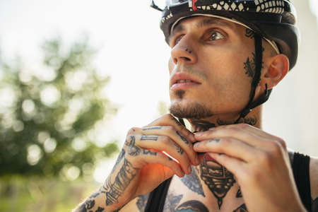 Young male cyclist wearing protective helmet before riding a bike. Active lifestyle conceptの写真素材