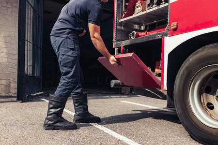 Fireman working with firefighting truck full of resque equipmentの写真素材