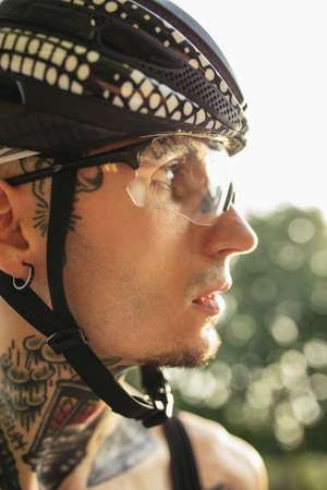 Close-up young sportive male cyclist portrait looking away, outdoorsの写真素材