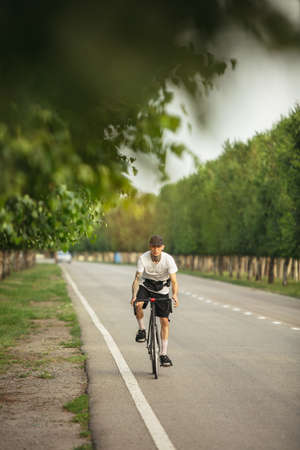 Young male sportsman riding a bike on open airの写真素材