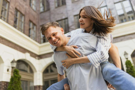 Funny portrait of young beautiful couple in motion outdoors on warm summer day