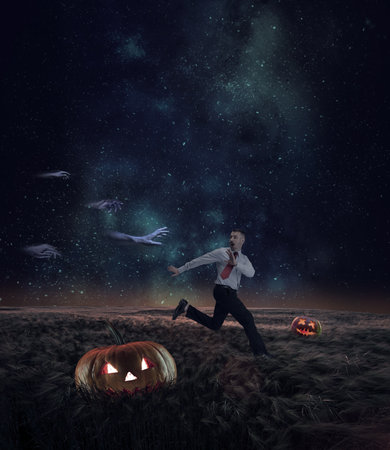 Terrifying man running away from ghost hands at nightの写真素材