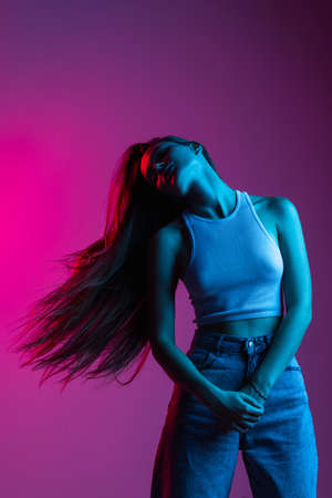 Young beautiful girl in motion isolated on pink purple backgroundの写真素材