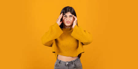 Cropped portrain of young beautiful expressive girl isolated on orange studio background