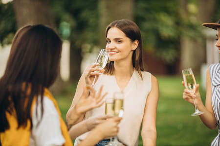 Joyfull girls having picnic in countryside on warm summer day. Pleasant activityの写真素材