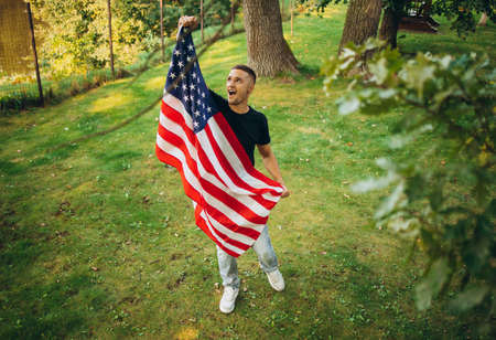 Top view portrait of young handsome man holding flag of America
