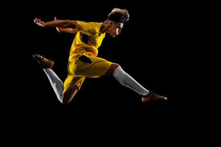 One profession young male football player training on black backroundの写真素材