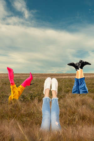 Contemporary art collage of human legs sticking out autmn field