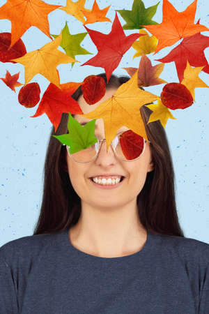 Contemporary art collage of smiling woman in glasses and colorful leaves in heart shape. Autumn conceptの写真素材