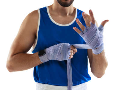 Cropped image of professional boxer tying boxing handwraps isolated over white background. Trainingの写真素材