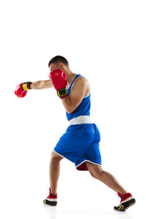 Strong fists. One professional boxer in blue uniform training isolated over white backgroundの写真素材