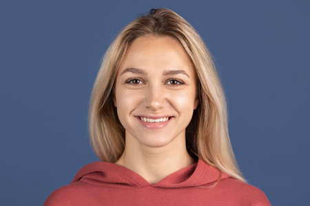 One beautiful caucasian girl posing isolated over blue background. Smiling