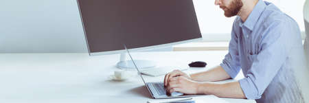Cropped side view of motivated employee working on new business project on laptop in the office....