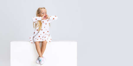 Full-length portrait of little preschool girl shouting isolated over white studio background.の写真素材
