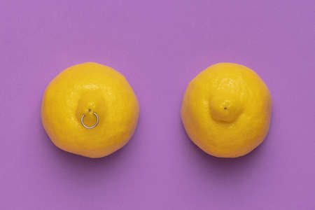 Contemporary art collage of two lemons with piercing isolated over purle backgroundの写真素材
