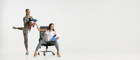 Full-length image of two female workers isolated over white background. Hard work of personal assistant. Flyerの写真素材