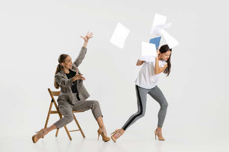 Stressful job. Angry business woman and assistant isolated over white backgroundの写真素材