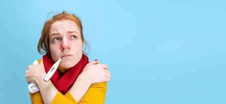 Cropped portrait of young woman having a cold isolated over blue background. Flyer