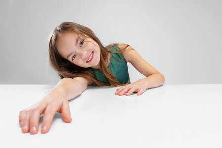 Cropped portrait of little girl, happy child posing, smiling at camera isolated over gray backgroundの写真素材