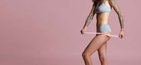 Cropped portrait of beautiful female body isolated over pink background. Body positivity. Flyerの写真素材