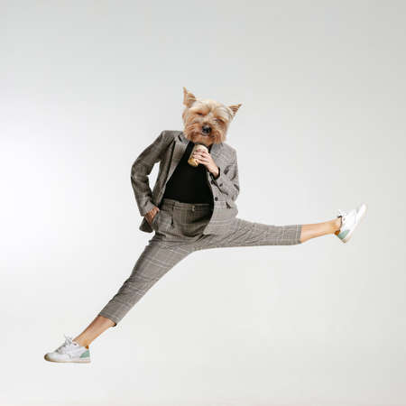 Contemporary art collage of female emolyee, woman in a suit with a dog head hoding coffee cup isolated over white backgroundの写真素材