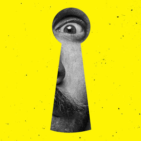 Contemporary art collage of man looking through the keyhole isolated over yellow backgroundの写真素材
