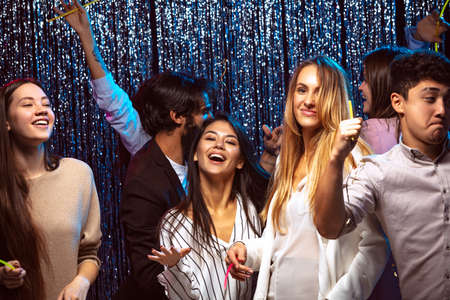 Group of cheerful young people dancing at the party, having fun togetherの写真素材