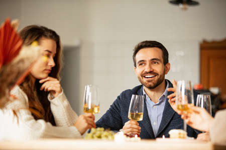 Cropped portrait of young man and woman having meeting at cafe with glass of white wineの写真素材