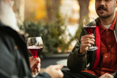 Glasses of delicious red wine. Friends gathering at cafe on warm autumn dayの写真素材
