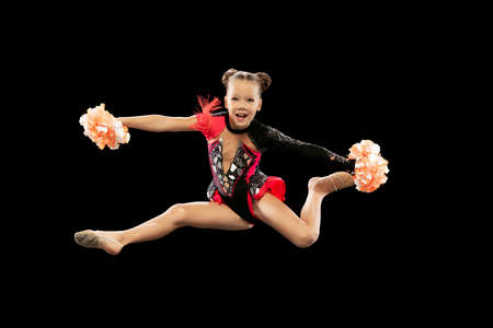 Full-length portrait of beautiful girl, cheerleader training, making movements in a jump isolated...