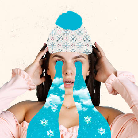 Contemporary art collage of girl crying with snowflakes and sky isolated over white backgroundの写真素材
