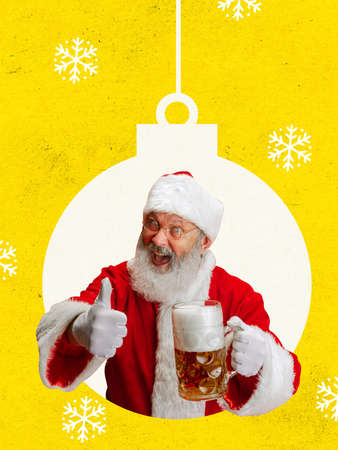 Contemporary art collage of joyful Santa holding lager beer glass and showing like gesture isolated over yellow backgroundの写真素材