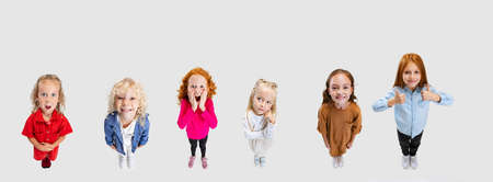 Collage of beautiful joyful children, kids, boys and girl posing, looking up isolated over white...