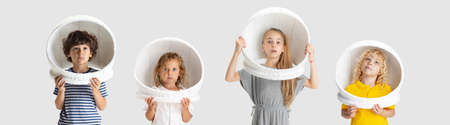 Collage of four playful joyful children, kids, boys and girl in astronaut helmets posing isolated...