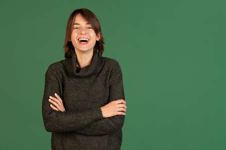 Cropped portrait of young woman joyfully smiling isolated over green backgroundの写真素材