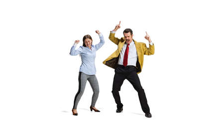 Full-length portrait of two cheerful workers dancing due to end of working week isolated over white...