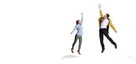 Full-length portrait of two excited worker jumping isolated over white backgroundの写真素材