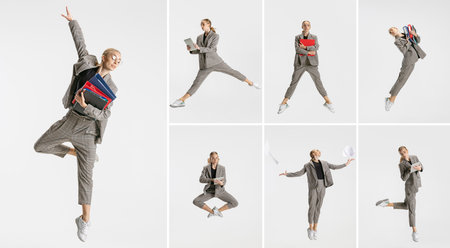 Collage of young woman in official suit, office employee dancing, jumping isolated over white backgroundの写真素材