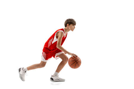 Full-length portrait of professional basketball player dribbling ball in motion, training isolated over white backgroundの写真素材