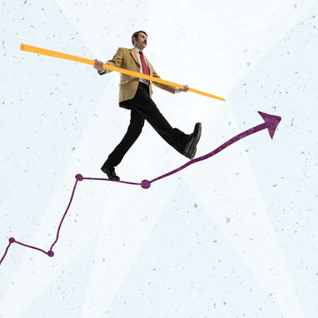 Creative design. Contemporary art collage. Businessman, manager, team leader balancing on arrow graphの写真素材