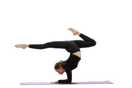 Portrait of young fit girl doing special yoga poses for stretching isolated over white studio...